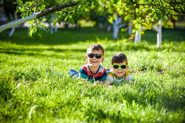 Glücklich lächelnder Geschwisterbruder entspannt sich auf dem Rasen. schließen u — Stockfoto