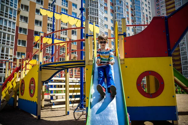 Verão, infância, lazer, amizade e conceito de pessoas - menino feliz no parque infantil escorregou da colina — Fotografia de Stock