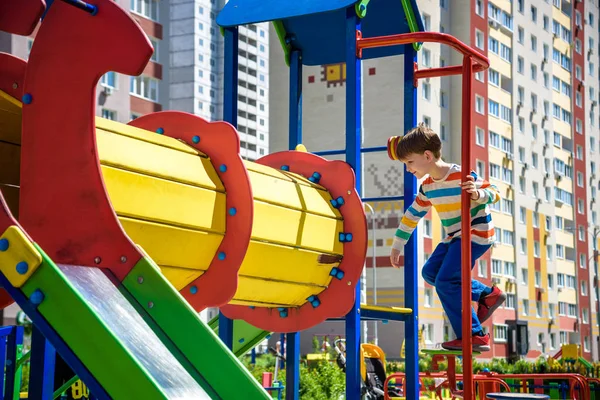 Menino feliz brincando em tubo ou túnel no playgro moderno — Fotografia de Stock