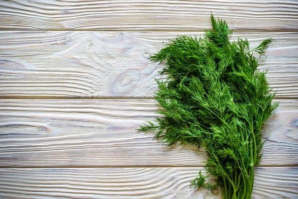 Bunch of dill isolated on a wooden background with space for text. Top view. Selective focus. Food for vegetarians