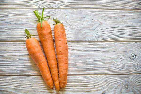 Carrots on wooden table background. Copy space. Top view