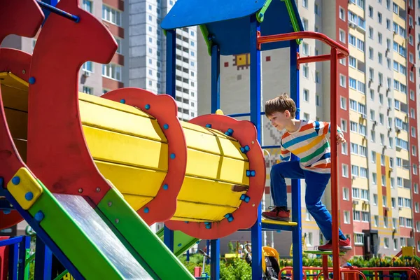 Menino feliz brincando em tubo ou túnel no playground moderno. Férias de verão. Infância feliz e saudável — Fotografia de Stock