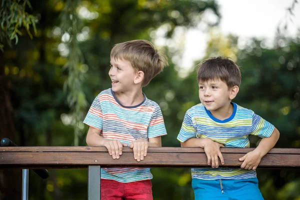 Dos niños en el senderismo, de pie y mirar el horizonte rodeado de cálidos colores soleados. Concepto de amistad entre hermanos, familia feliz — Foto de Stock