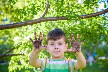 Kirli ellerini oynadıktan sonra gösterilen genç bir beyaz çocuk 