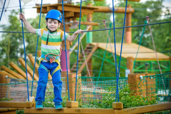 Мальчик веселится в парке приключений. лазание на верёвке — стоковое фото
