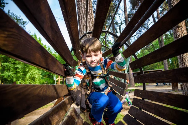 Happy Kid övervinner hinder i rep äventyrs Park. Sommar hol — Stockfoto