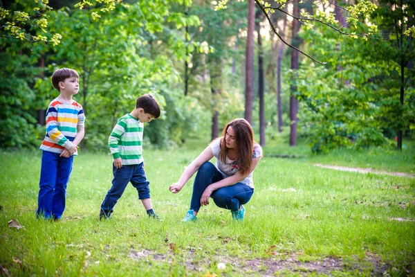 Młoda kobieta matka stosowania owadów odstraszający do jej dwóch syna befo — Zdjęcie stockowe
