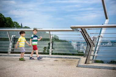 İki erkek çocuk portresi bir köprü üzerinde yürüyüş ve aşağı bakıyor, 