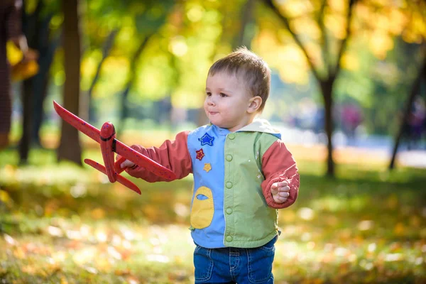 Niño feliz jugando con el avión de juguete contra el cielo azul de verano espalda — Foto de Stock