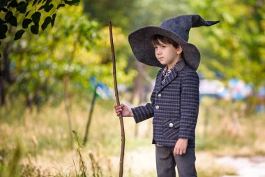 Açık havada sihirli değnek ile oynayan sivri şapkatoddler çocuk. Yaktı