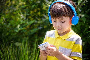 Sevimli çocuk onun mutlu ile şarkı açık dinleme kulaklık kullanarak