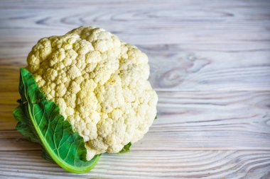 Taze beyaz kafaları karnabahar için bir hasır sepet içinde karnabahar temizlenir. Rustik gri ahşap arka plan. Üst görünüm, boş alan.