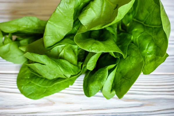 Head of fresh butter lettuce in a white bowl on a wood background