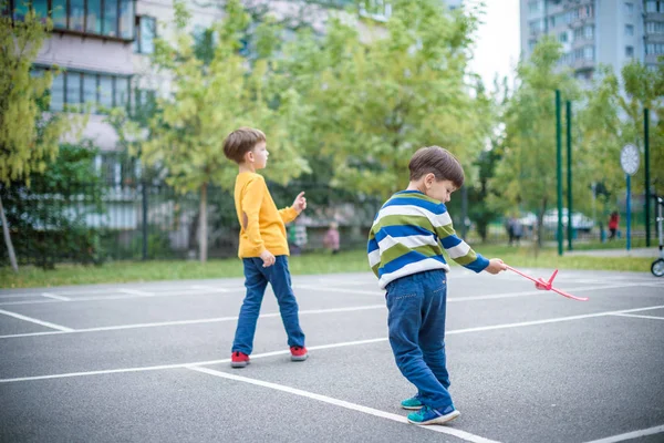 Feliz dos hermanos niños jugando con juguete avión contra azul su — Foto de Stock