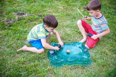 İki erkek ile modern spin üst açık havada oynuyor. Çocuklar için oyun eğlence. Üst, tetikleyici tarafından tetiklenen. Bir turnuva arena ya da savaş alanına sahip çocuklar. Üstten görünüm.