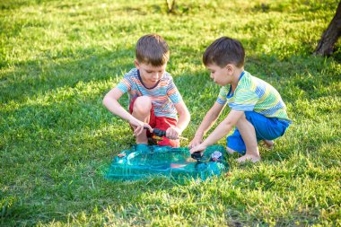 İki erkek ile modern spin üst açık havada oynuyor. Çocuklar için oyun eğlence. Üst, tetikleyici tarafından tetiklenen. Bir turnuva arena ya da savaş alanına sahip çocuklar.