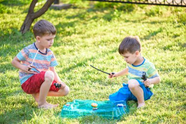 İki erkek ile modern spin üst açık havada oynuyor. Çocuklar için oyun eğlence. Üst, tetikleyici tarafından tetiklenen. Bir turnuva arena ya da savaş alanına sahip çocuklar.
