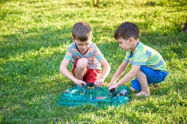 Two Boys Playing Modern Spin Top Outdoors Entertainment Game Children Stock Image