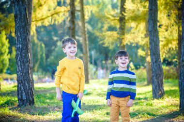 Mavi yaz gökyüzü arka planında oyuncak uçakla oynayan mutlu iki kardeş. Çocuklar ormana ya da parka köpük uçak fırlatırlar. En iyi çocukluk kavramı.