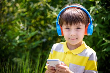 Sevimli çocuk onun mutlu yüzü ile şarkı açık dinleme kulaklık kullanarak. Müzik dinlemek için Usb çalar kullanırken eğlenen kafkas çocuk.