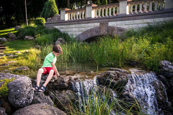 Chico Joven Sienta Orilla Del Río Sueña Cálido Día Verano — Foto de Stock