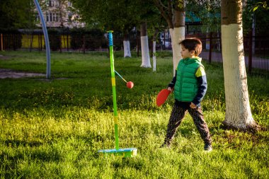 Mutlu çocuk yaz kampında tetherball swing oyunu oynuyor. Boş vakitleriniz kutlu olsun. Açık hava konsepti..