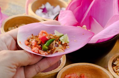 Bir ısırık o isthai kırmızı lotus yaprağı (http://i50.tinypic.com/5yvink.jpg Kam) ile sarın ve Laos geleneksel çerezim ahşap masa 