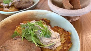 Mantar sosu ve roka ile servis edilen öğle yemeği ve patates krepleri. Lokantada servis edilen ekşi kremalı Ukrayna çorbası. Yüksek kalite 4k görüntü