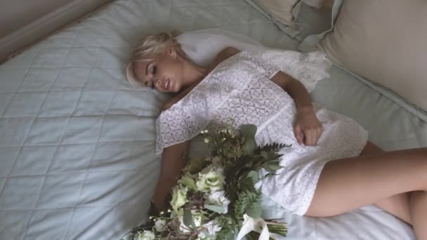 Bella sposa in lingerie bianca sdraiata sul letto nella sua camera da letto — Video Stock