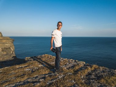 Inishmore adanın uçurumun kenarında bir adam bir dron konsol elinde tutuyor.