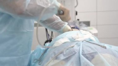 Liposuction işlemi. Doktor yağ torasik arkadan toplar.