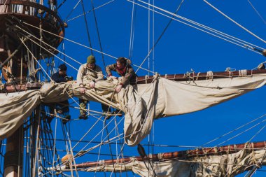 Denizciler iş geleneksel bir yelkenli üzerinde bir yükseklikte yelkenli