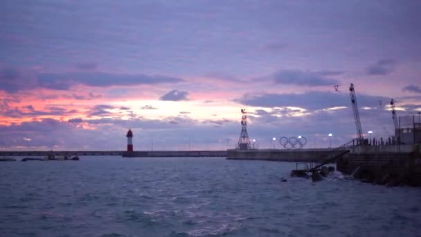 Nuvens cor-de-rosa flutuam sobre o mar negro em Sochi durante o pôr do sol — Vídeo de Stock