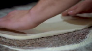 Şef pizza, ağır çekim için elleriyle hamur rulo