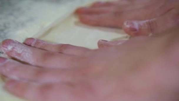 Шеф-повар катит тесто руками для пиццы, замедленная съемка — стоковое видео
