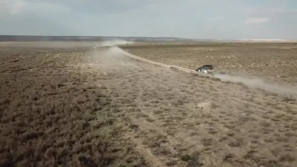L'auto attraversa il deserto lasciando polvere. Località nel paese di Kazakistan, simile a Arizona — Video Stock