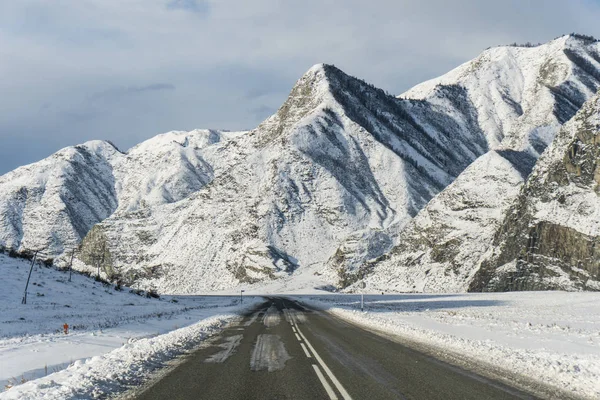 Rodovia de inverno russa entre as montanhas de Altai no inverno Imagens De Bancos De Imagens