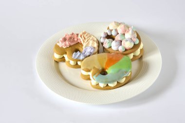 Beyaz bir plaka üzerinde renkli kurabiye.