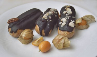 Bir plaka ve Physalis üzerinde Eclairs.