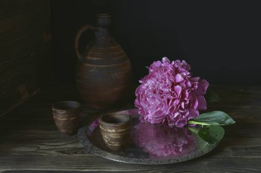 Şakayık ve metal tepside bir parça Elma.