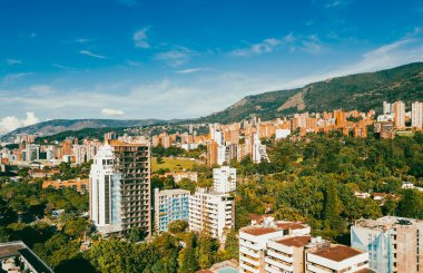 Medellin, Antioquia, Kolombiya. 13 Aralık 2020: Mavi gökyüzü ve binaları olan şehir manzarası.