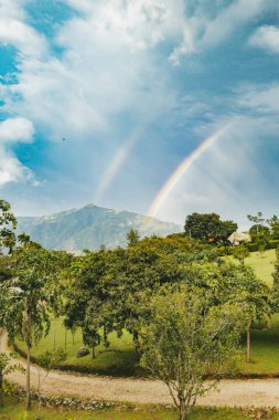 Venedik, Antioquia, Kolombiya 'da yolu ve gökkuşağı olan kırsal alan.