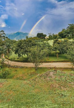 Venedik, Antioquia, Kolombiya 'da yolu ve gökkuşağı olan kırsal alan.