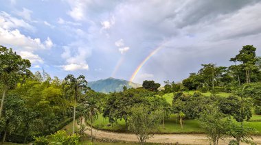 Venedik, Antioquia, Kolombiya 'da yolu ve gökkuşağı olan kırsal alan.