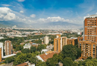 Medellin, Antioquia, Kolombiya. 14 Ocak 2021: El Poblado mahallesi ve mavi gökyüzü binalarıyla manzara.