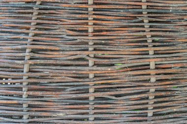 Orta Avrupa 'da eski bir köyün doğal liflerinden ya da dallarından yapılmış eski, dokuma bir yapı kibrit çitinin yakın çekimi. Dağınık ışıklandırmalı Dünya renk paleti.