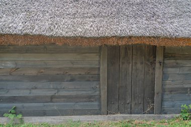 Orta Avrupa 'nın eski bir köyünde sazdan çatılı, taşralı, ahşap bir bina sessiz renk paleti koyu kahverengi, açık renk, insan ya da hareket eden nesne yok.
