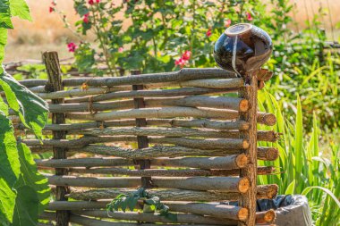 Orta Avrupa 'da eski bir köyün arka planına karşı kırsal ahşap bir bank. Bulutlu bir gökyüzü altında. Doğal, organik tasarım.