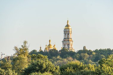 Birçok kubbe ve minareye sahip büyük dini yapı, yemyeşil yeşilliklere karşı kurulmuş. Altın çatılar, sıcak güneş ışığı altındaki taş yapıya tezat oluşturuyor. Süslü mimari kültürel önemi gösteriyor.