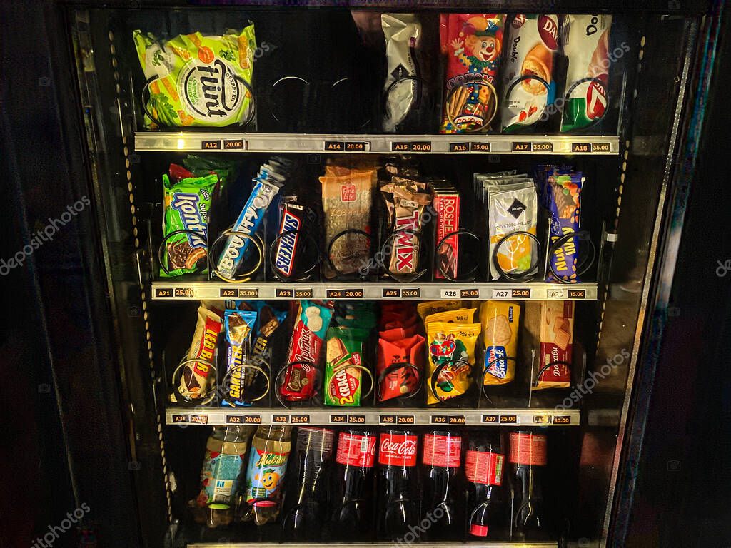 Ukrainian vending machine filled with beverages and snacks, including chips packages, soda cans, bottles of drinks, and an assortment of snack items on multiple shel Kyiv, Ukraine 07-02-2025